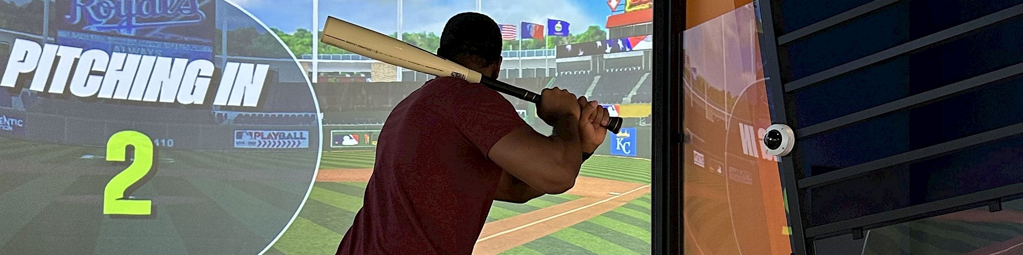 A person is playing a baseball simulation game, preparing to bat with "KC Royals" and "PITCHING IN 2" on the screen.
