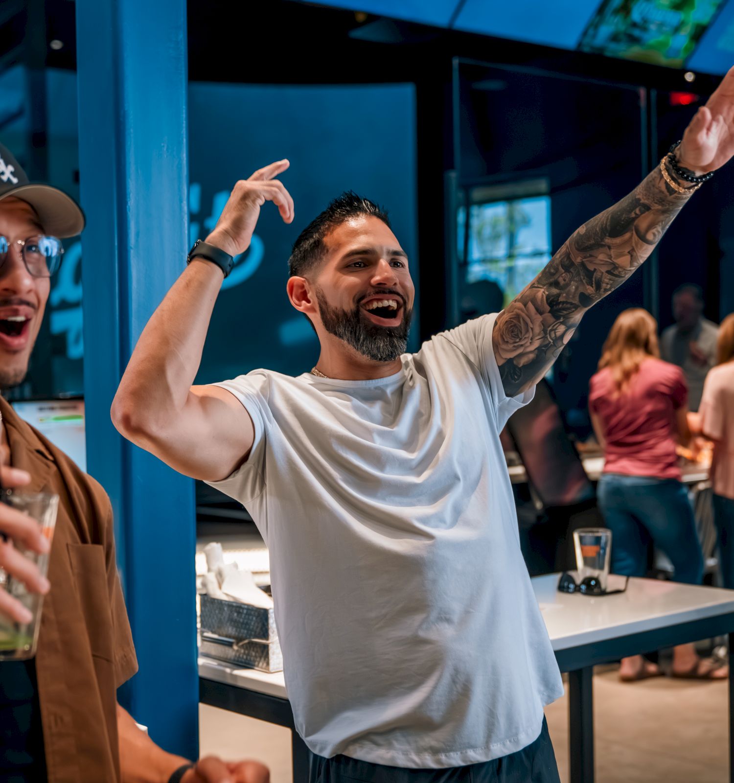 People are enjoying and celebrating indoors, with drinks and lively gestures.